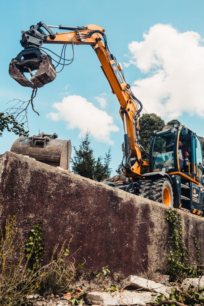 A bulldozer efficiently demolishing an old building, clearing rubble.