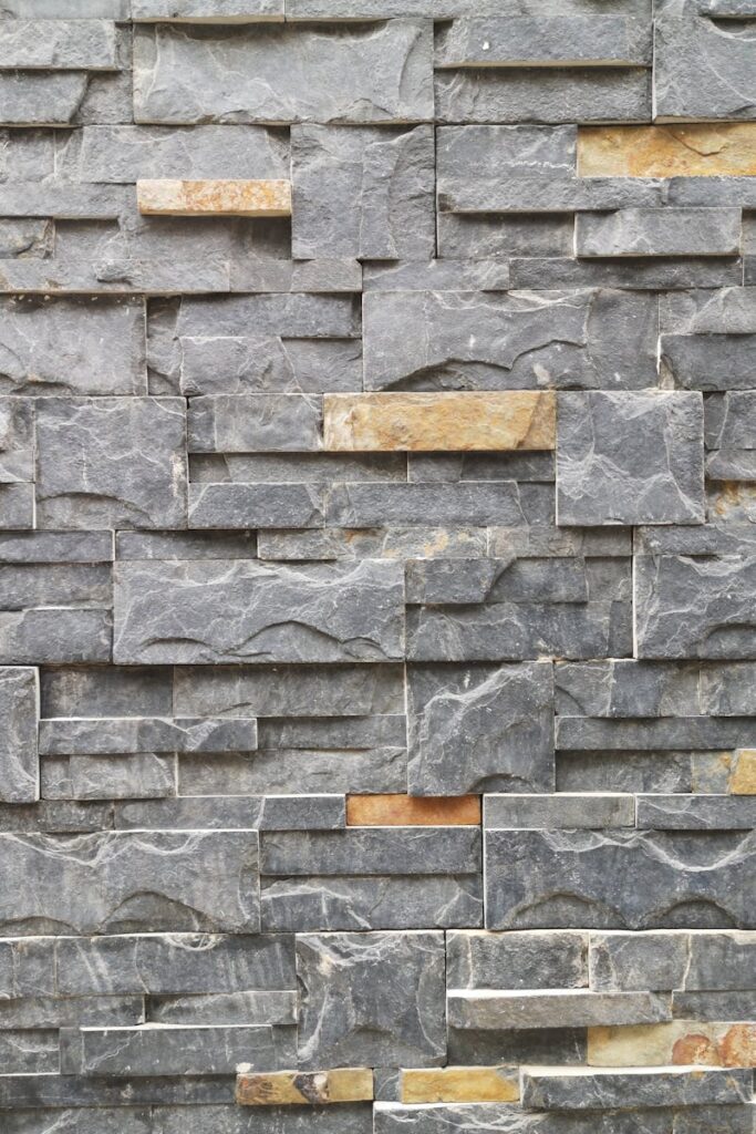 A close-up of a textured stone wall made of slate and granite bricks for architectural design.