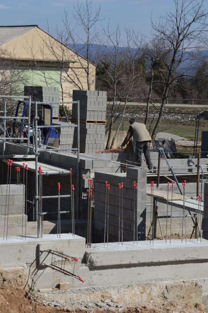 Construction workers building a concrete structure at a sunlit site.